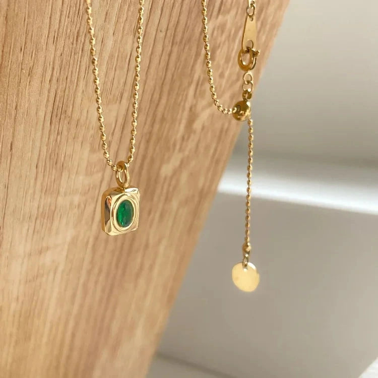View of a vintage necklace featuring a delicate chain and a stunning peridot gemstone pendant, showcasing its refined design