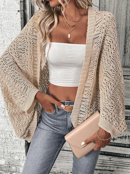 Model wearing Khaki boho delicate summer cardigan, white tube top, and jeans, holding a clutch in an urban setting.