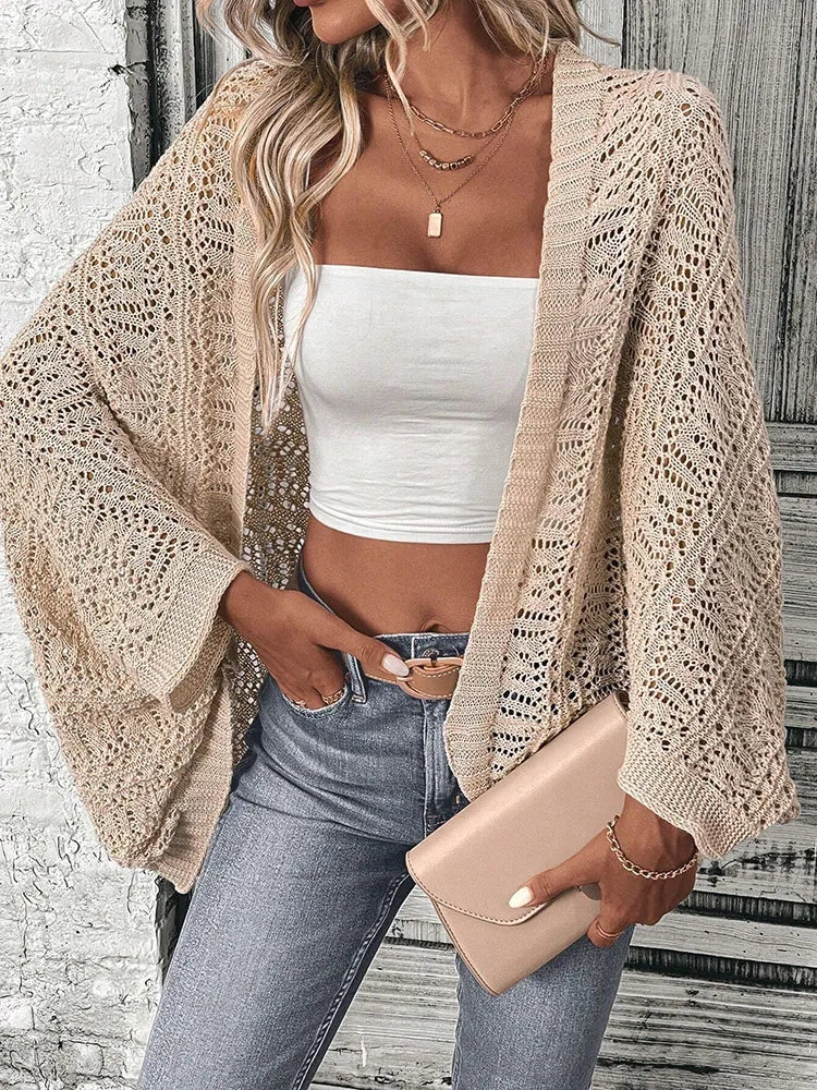 Model wearing Khaki boho delicate summer cardigan, white tube top, and jeans, holding a clutch in an urban setting.