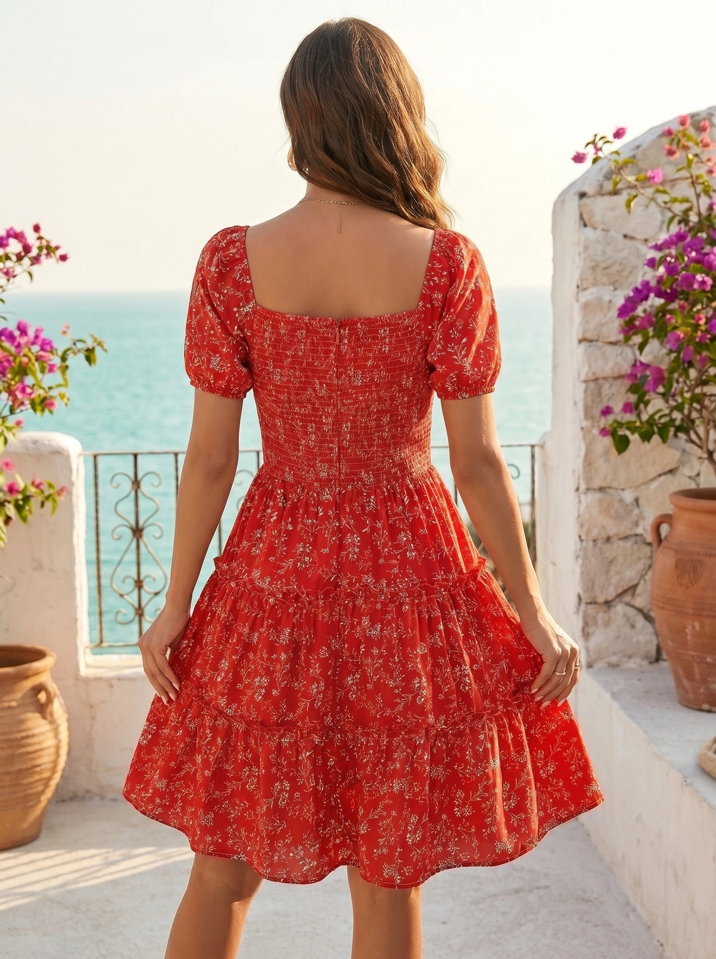 Back view of a model wearing a women's slim summer dress in a soft pastel color, showing the construction details against a sunny beach backdrop.
