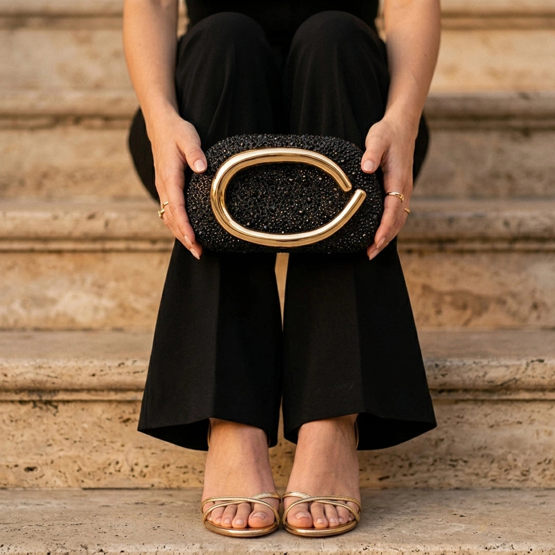 Elegant black clutch bag with a textured finish, featuring sleek silhouette and decorative clasp, front view — 19 — view 19