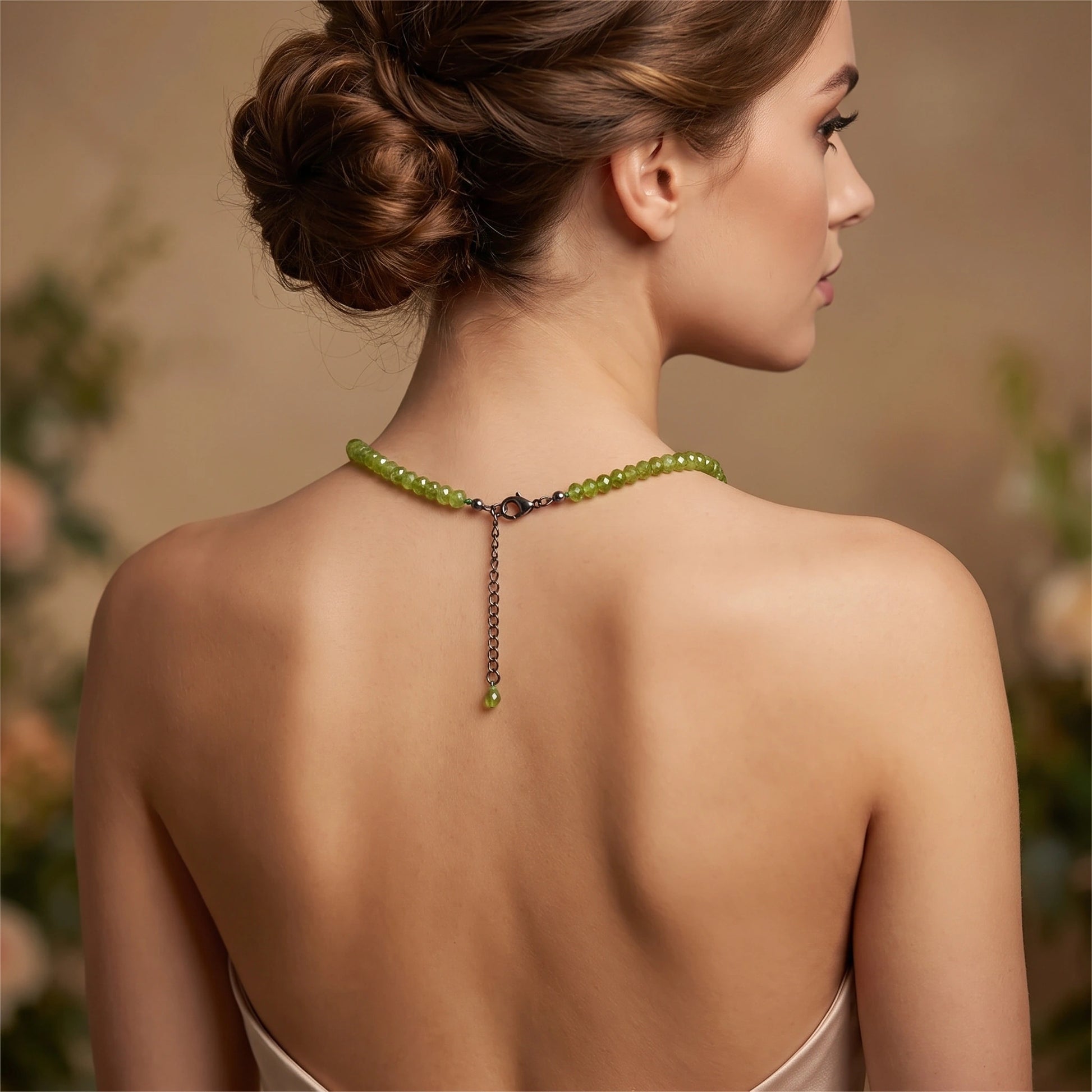 Close up view of the Womens Classic Peridot Necklace showing intricate detailing and vibrant green stones against a soft, neutral fabric background.