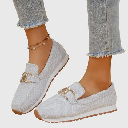 View of elegant women's loafers in soft beige leather, featuring a breathable design and subtle stitching accents