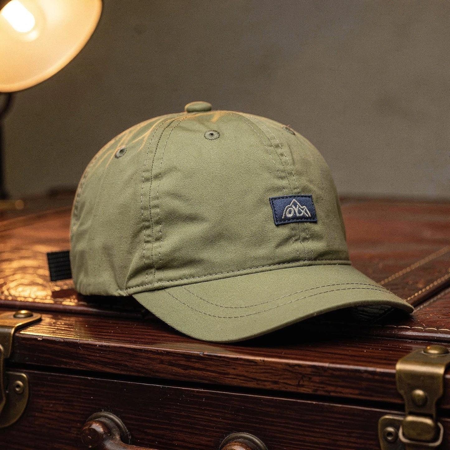 View of a navy blue baseball cap made from breathable fabric, featuring an adjustable strap and curved brim