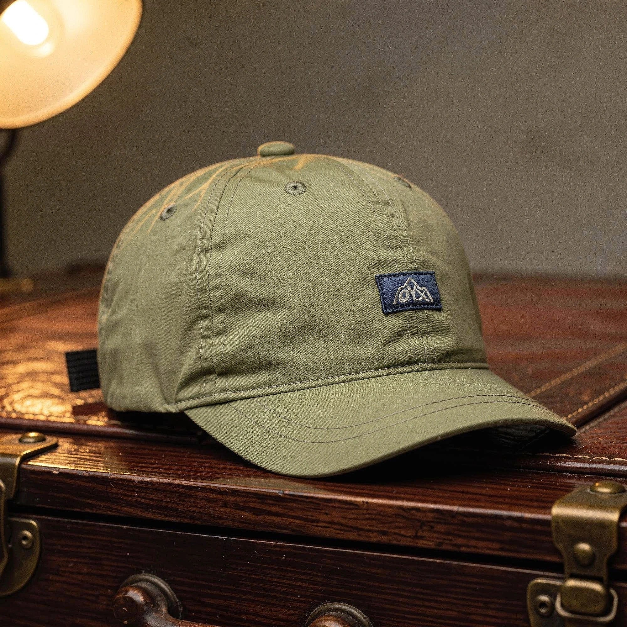 View of a navy blue baseball cap made from breathable fabric, featuring an adjustable strap and curved brim