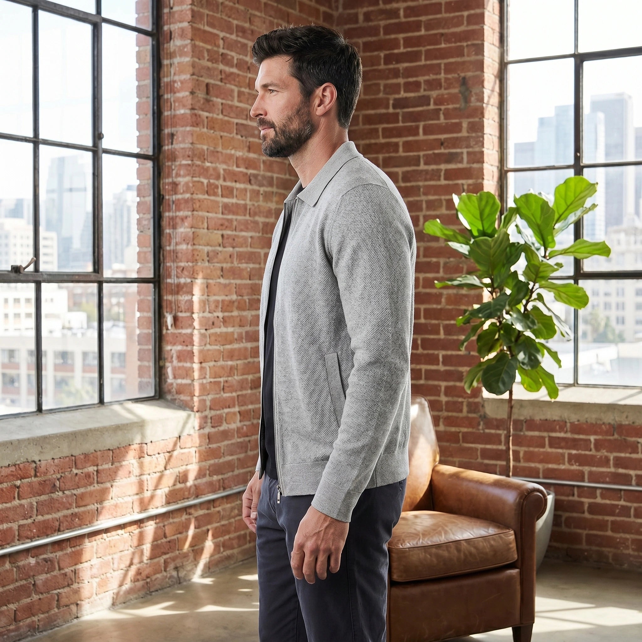 Back view of a model wearing a mens sophisticated versatile jacket in a deep navy color, showing the sleek construction and full zip design.