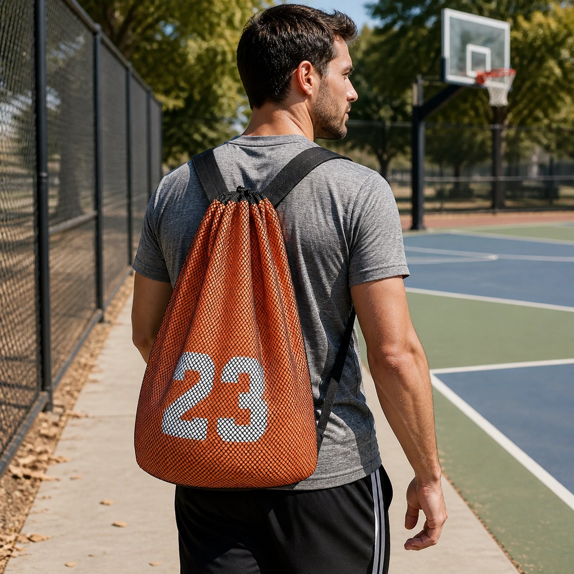 drawstring backpack — Adult wearing orange and black mesh athletic drawstring ball backpack at a basketball court — view 6