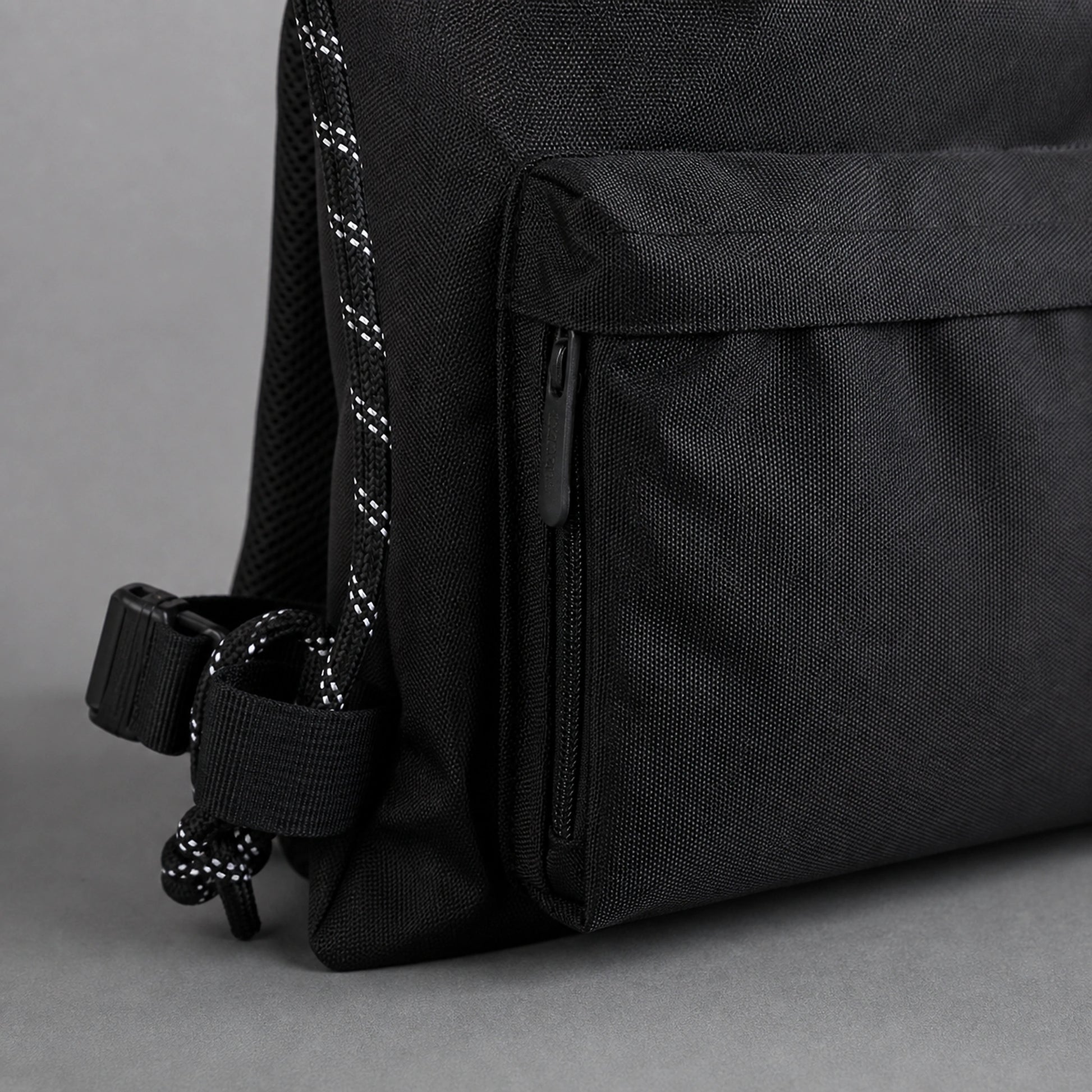 Black drawstring backpack, zipper cord and hardware detail — view 3