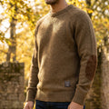 Close up of the Mens Timeless Relaxed Sweater showing the soft fabric, intricate stitching, and elbow patches against a neutral background.