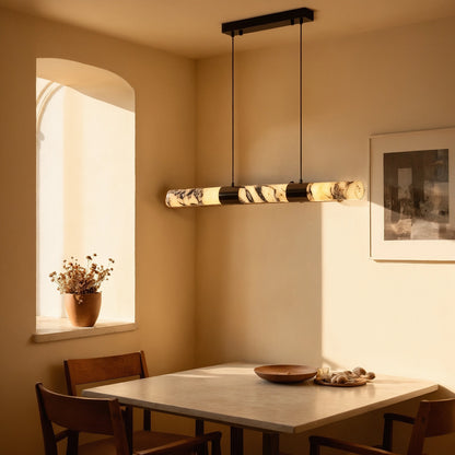 Close up view of the sophisticated marble dining room chandelier showing its intricate detailing, smooth alabaster finish, and design elements against a soft, white background.