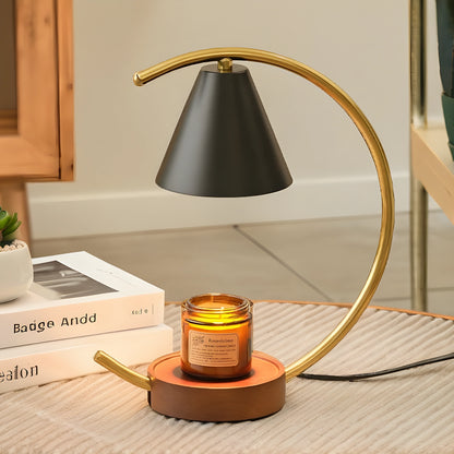 View of a sculptural dimmable candle warmer table lamp featuring a textured ceramic base in earthy tones and a soft, warm glow