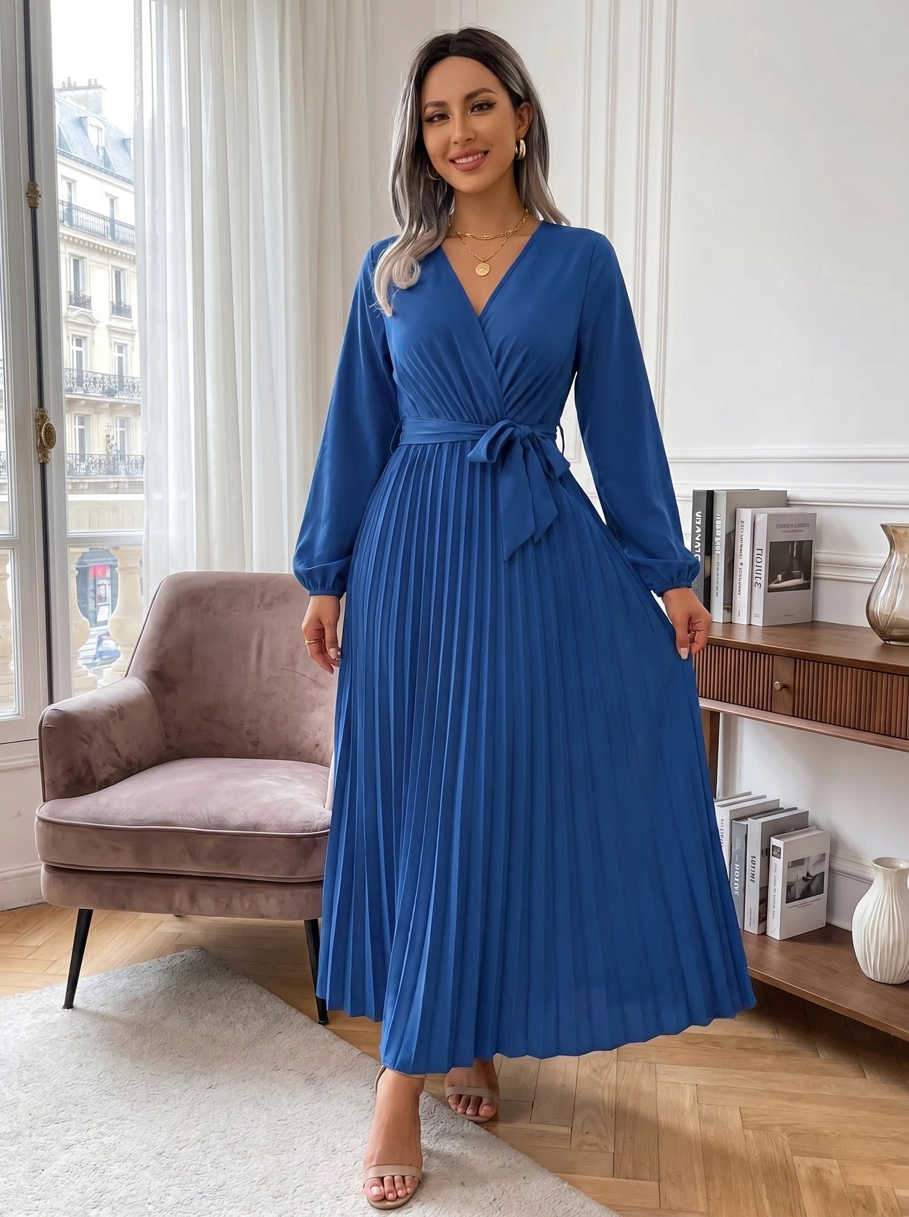 A model showcases the Women's Pleated Maxi Dress in a soft blush hue, elegantly styled against a neutral background, showing its flowing silhouette and sophisticated pleats.