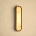 Elegant alabaster wall sconce with a sculptural design, featuring a soft ambient glow, view