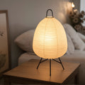 View of a serene minimalist rice paper table lamp, featuring a soft white shade and a natural wood base