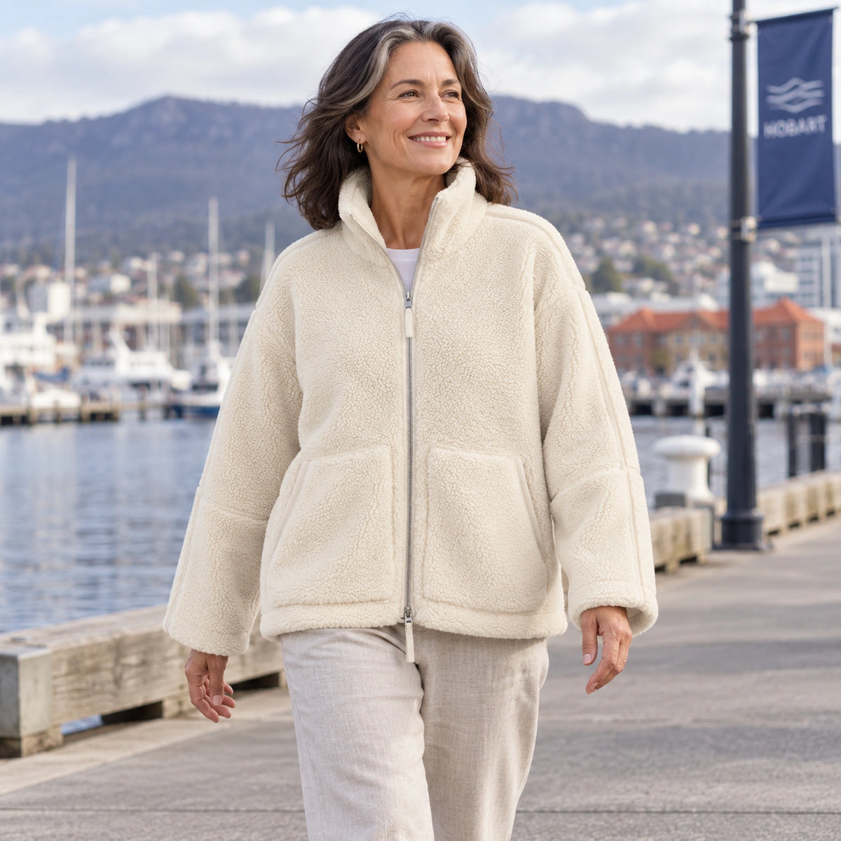 White Avalon fleece jacket, mature model walking at Hobart harbour — view 8