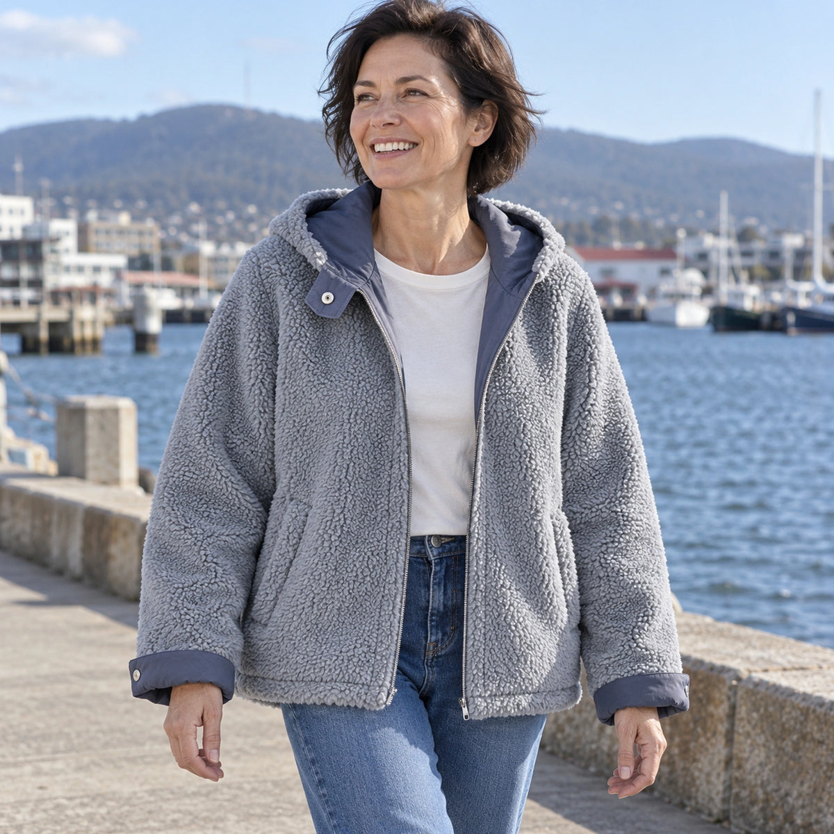 fleece jacket — Blue Freya reversible jacket, mature model wearing grey teddy fleece side by Tasmanian harbour — view 8