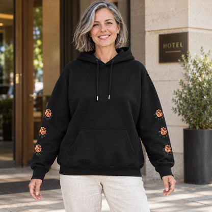 Black butterfly and rose print hoodie, complete front view on a mature model — view 5