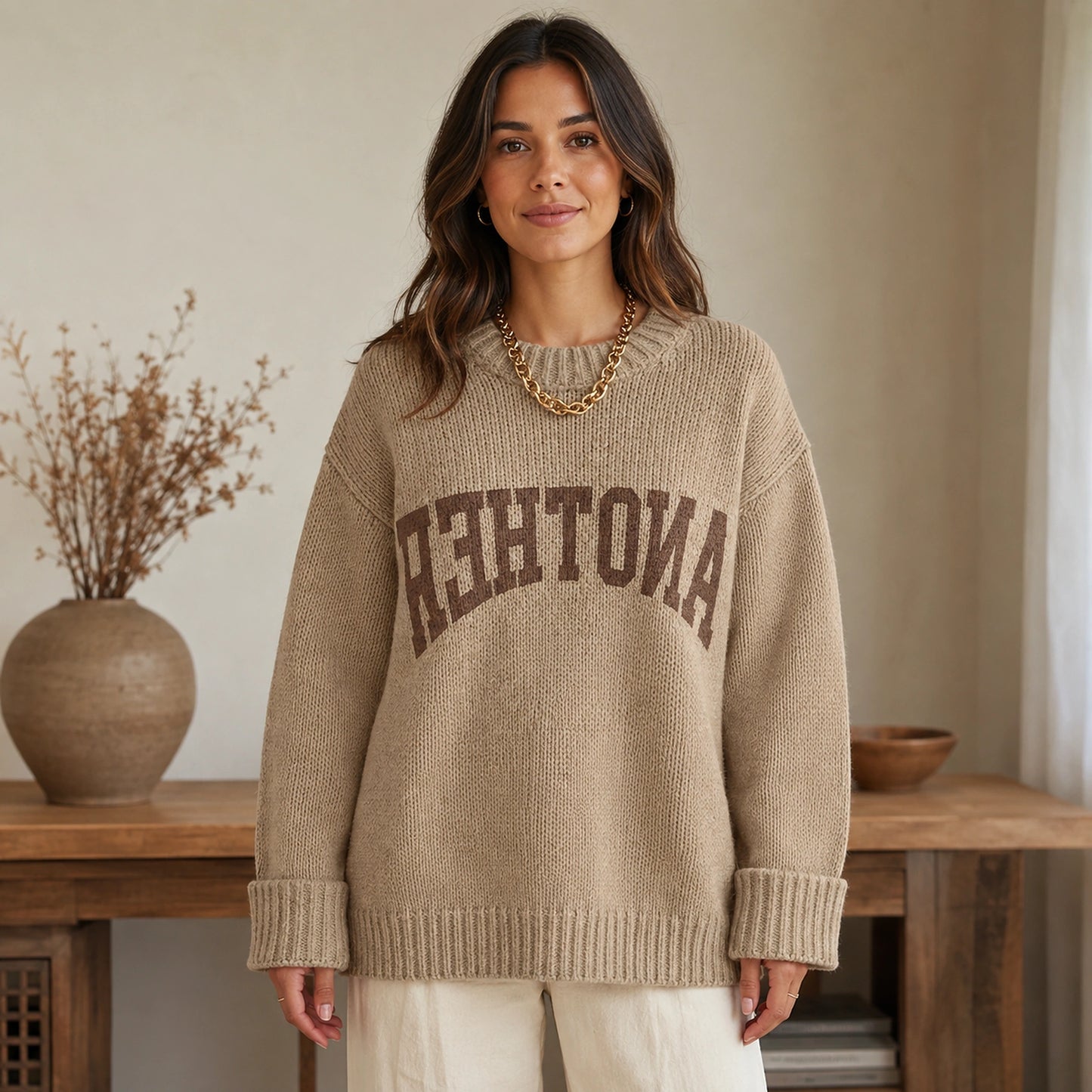 Woman wearing khaki collegiate letter letterman sweater, complete front view