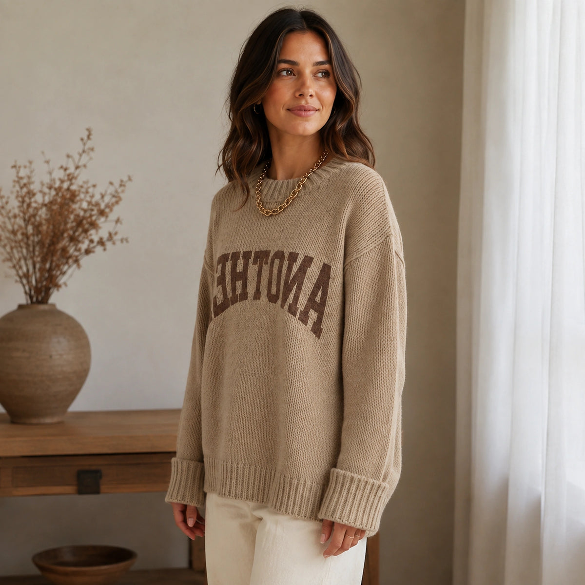 Woman wearing khaki collegiate letter letterman sweater, side view — view 6