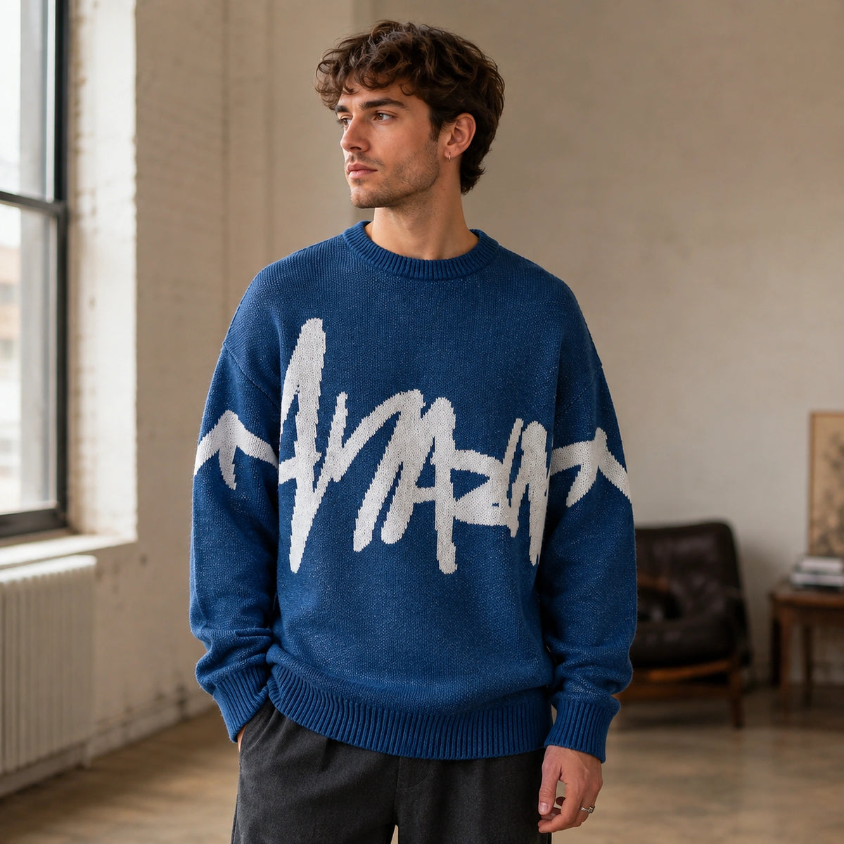 Man wearing blue graffiti jacquard letterman sweater, complete front view — view 2
