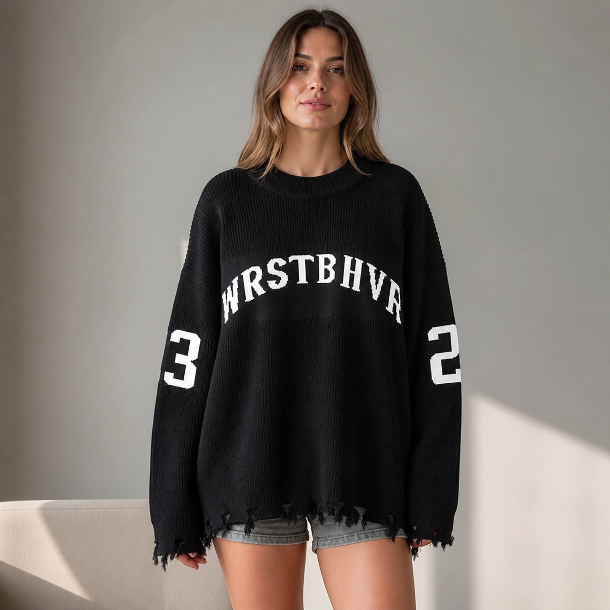 Woman wearing black oversized jacquard letterman sweater, complete front view — view 2