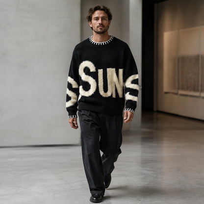 Man wearing black fuzzy letter pattern letterman sweater, complete front view — view 4