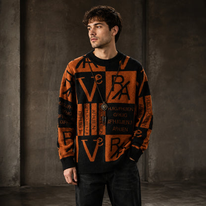 Male model wearing men's rust brown and black abstract jacquard letterman sweater, complete front view — view 2