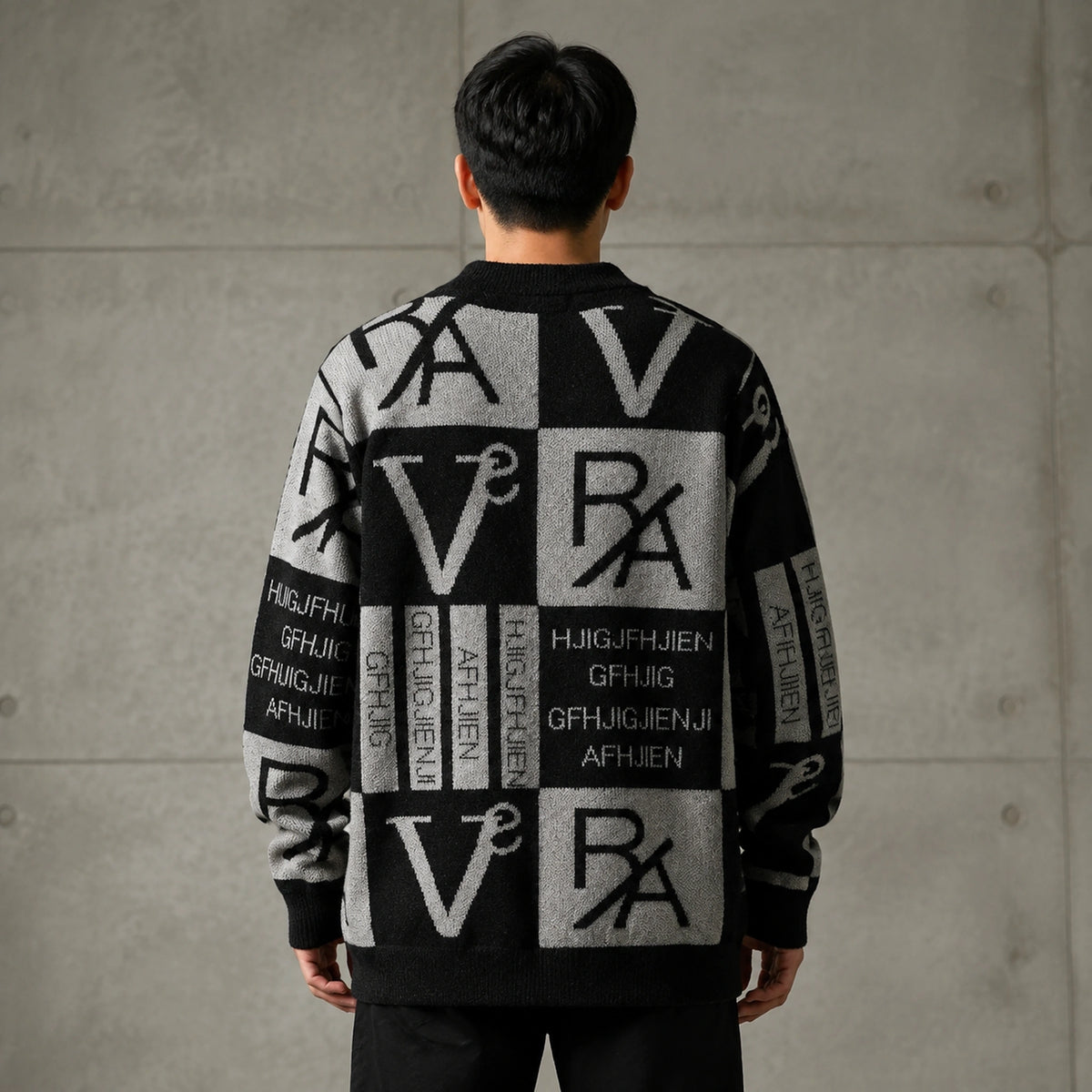 Male model wearing men's gray and black abstract jacquard letterman sweater, genuine direct rear view — view 4