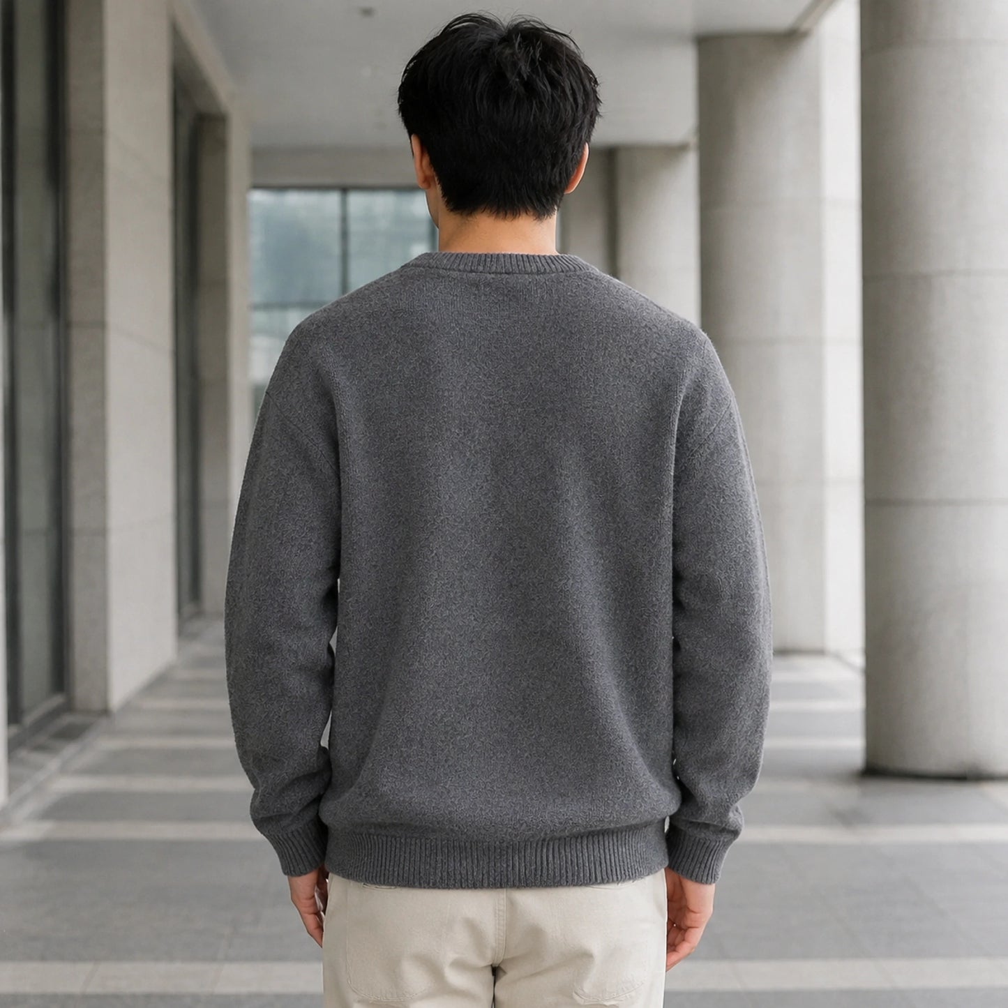 Male model wearing men's gray fleece lined patch letterman sweater, complete rear view — view 4