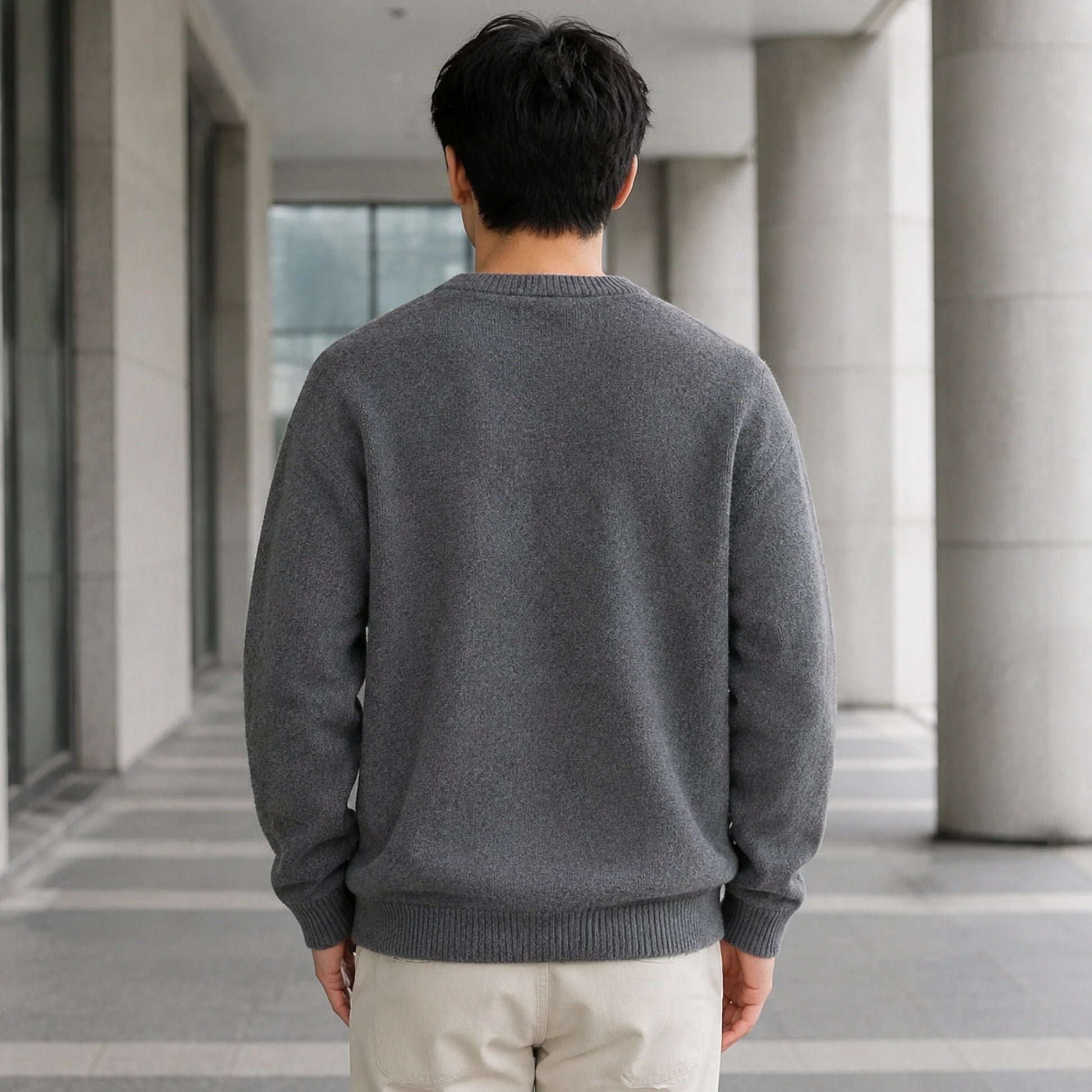 Male model wearing men's gray fleece lined patch letterman sweater, complete rear view — view 4