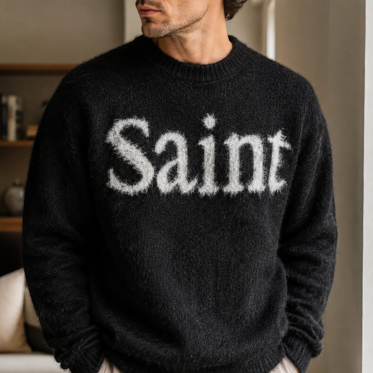 Close up of the black fuzzy Saint letterman sweater worn by a male model — view 4