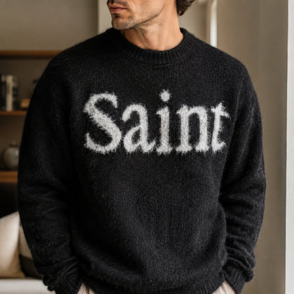 Close up of the black fuzzy Saint letterman sweater worn by a male model — view 4