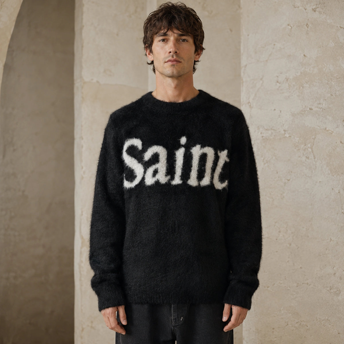 Male model wearing men's black fuzzy script letterman sweater, complete front view