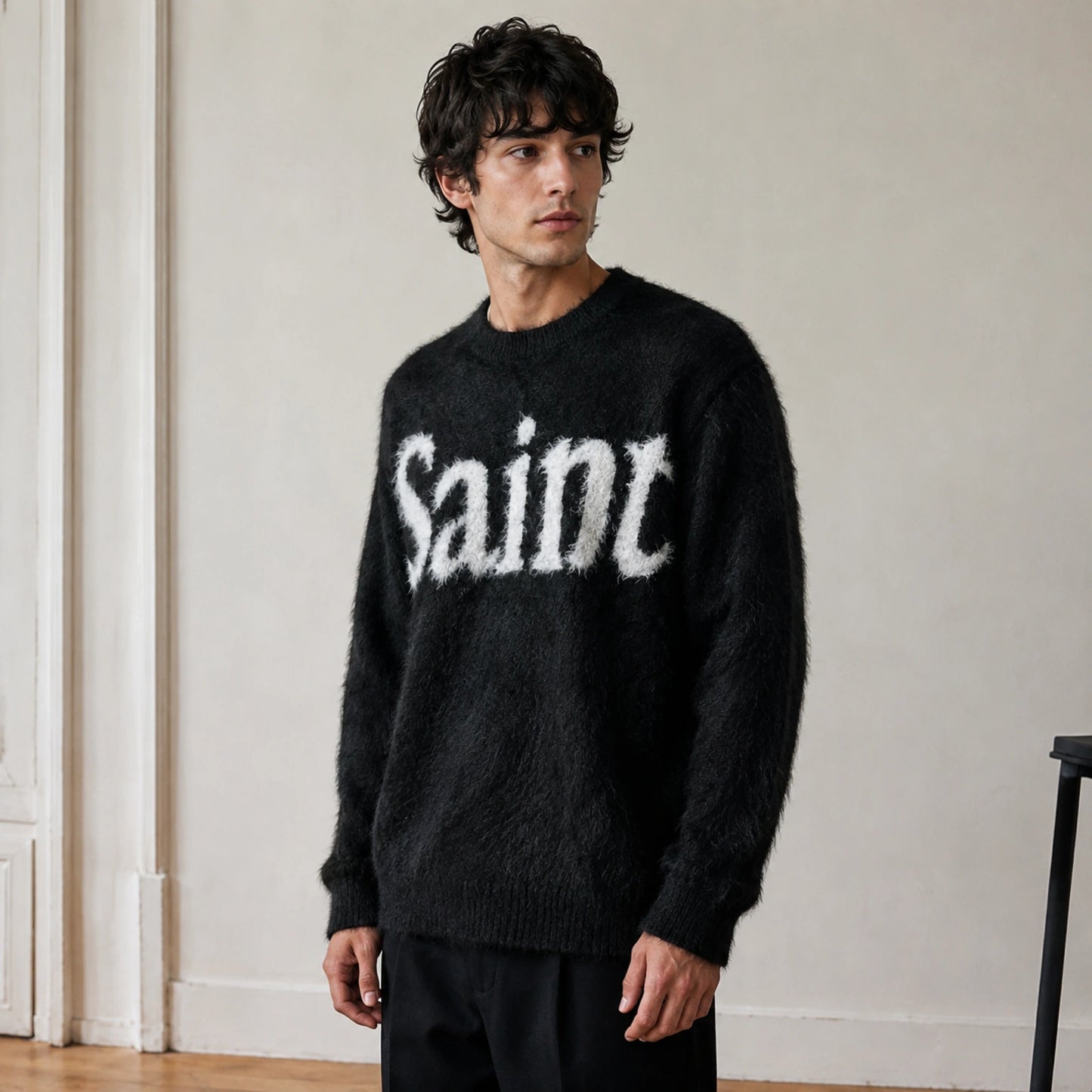 Male model wearing men's black fuzzy script letterman sweater, complete side view — view 3
