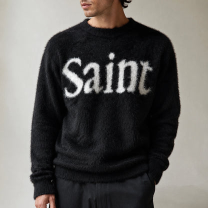 Male model wearing black fuzzy script letterman sweater, close up neckline and knit detail — view 4