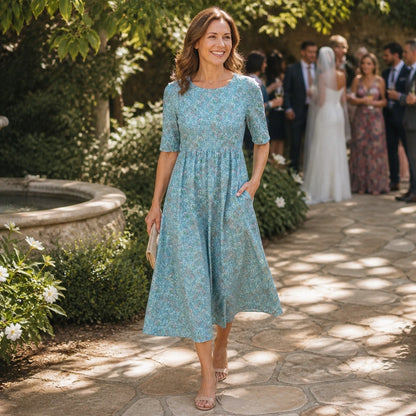 long wedding guest dress — Mature woman wearing blue floral midi wedding guest dress outdoors — view 5