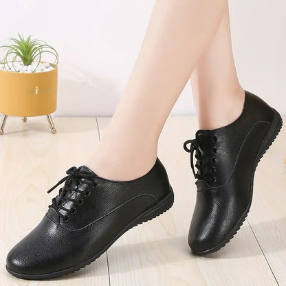 Black marching band shoes with lace up design and textured sole, shown on light wood floor — view 5 — view 4