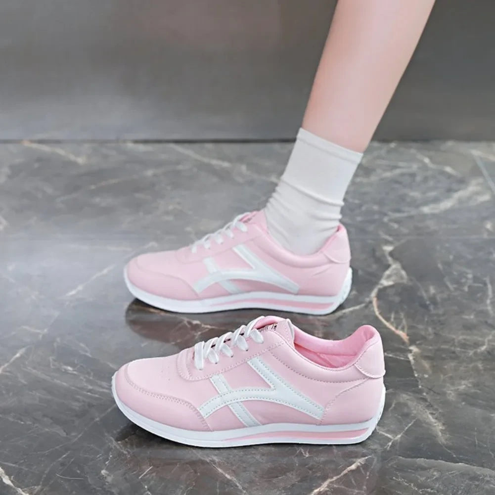 Pink low top marching band shoes with white laces and accents, worn socks — view 2
