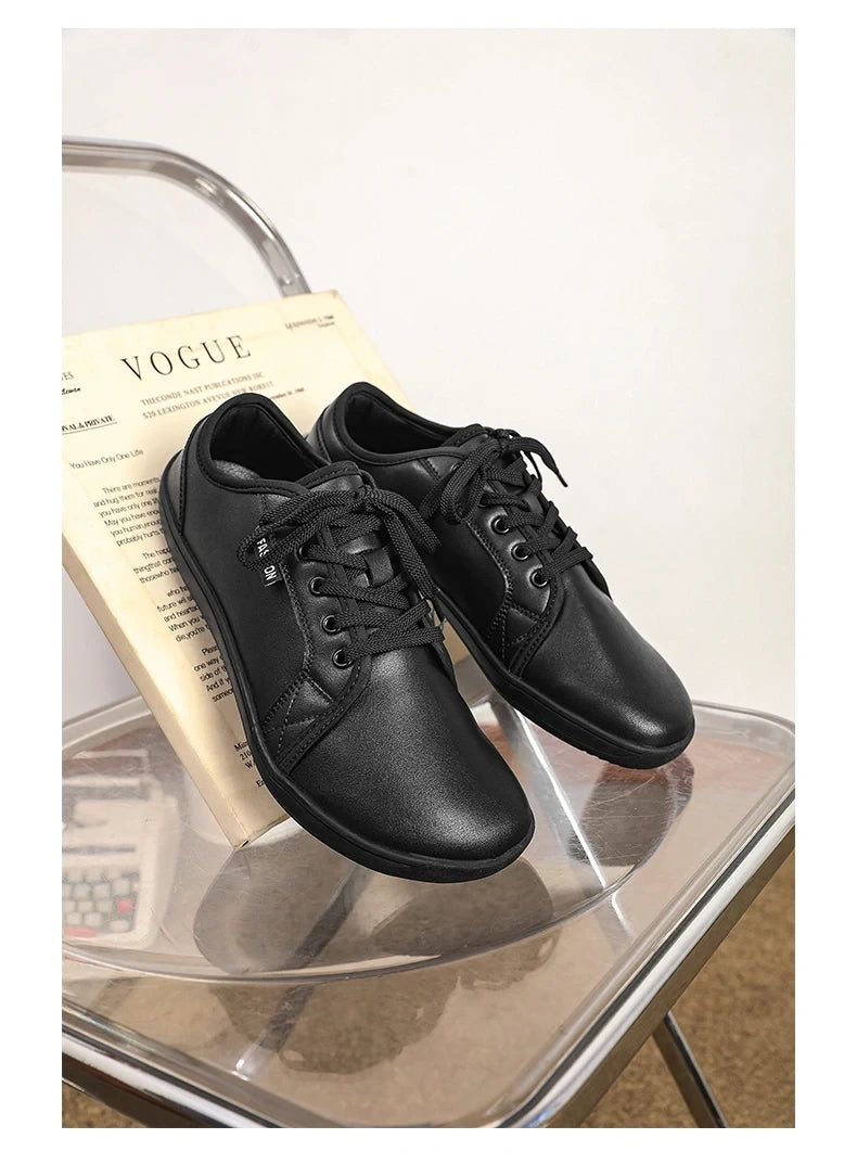 Black marching band shoes with laces on a clear chair, side view — 24 — view 7