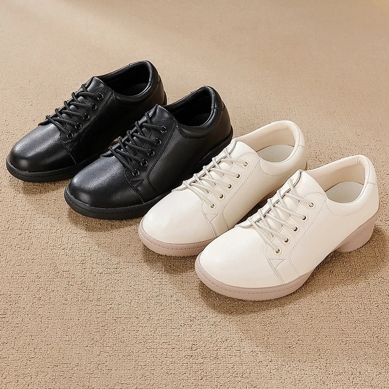 Black and white marching band shoes with lace up design on a beige surface — view 3 — view 2