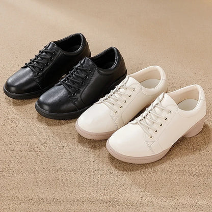 Black and white marching band shoes with lace up design on a beige surface — view 3 — view 2