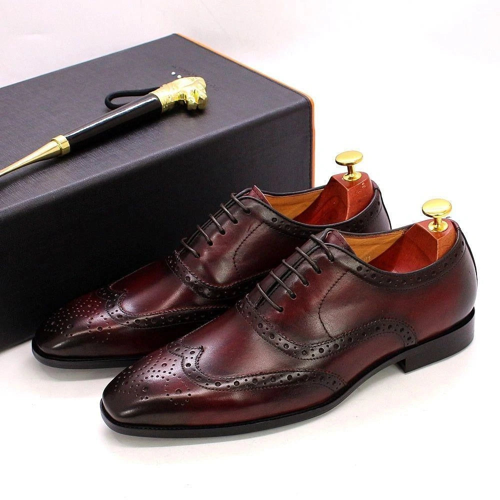Elegant oxford loafers in rich brown leather with intricate brogue detailing, displayed on a box — view 2