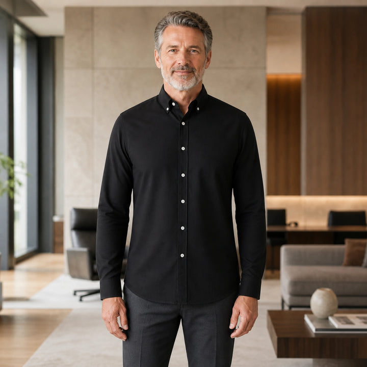 Mature man wearing Black smart casual long sleeve Oxford shirt, full front view with button down collar, cuffs, and curved