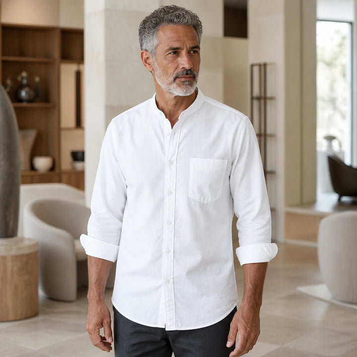Mature man wearing the white slim fit cotton Oxford shirt, full front view with stand collar, chest pocket, rolled cuffs