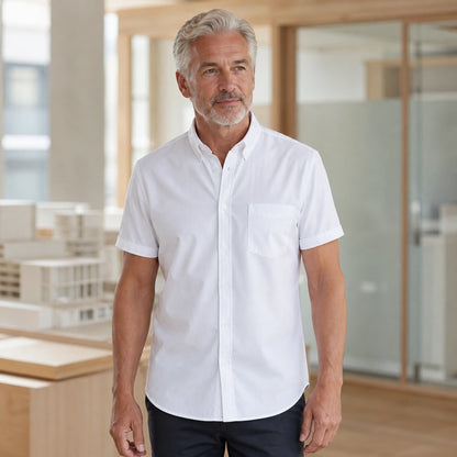 Mature man wearing the white short sleeved Oxford shirt, full visible in a bright architecture