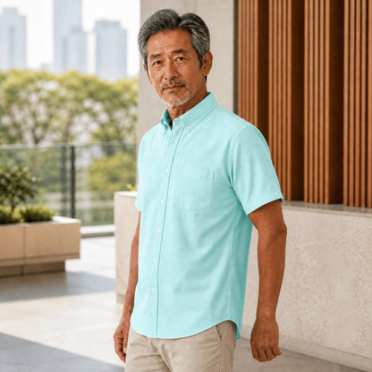 Side three quarter view of a mature man wearing the green Oxford shirt, showing pocket, rolled cuff, seam and — view 5