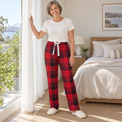 Red And Black Plaid pajama pants, complete garment on mature model beside a home bedroom curtain — view 8