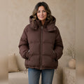 Woman wearing chocolate brown hooded puffer parka coat, complete front view