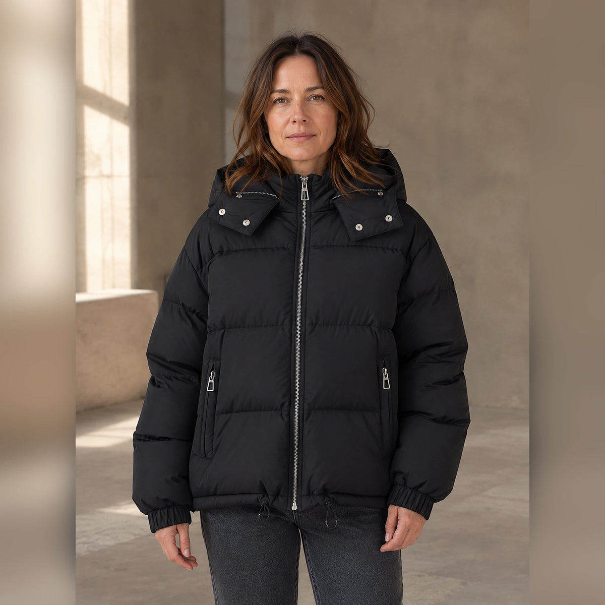 Woman wearing black hooded puffer parka coat, complete front view — view 3
