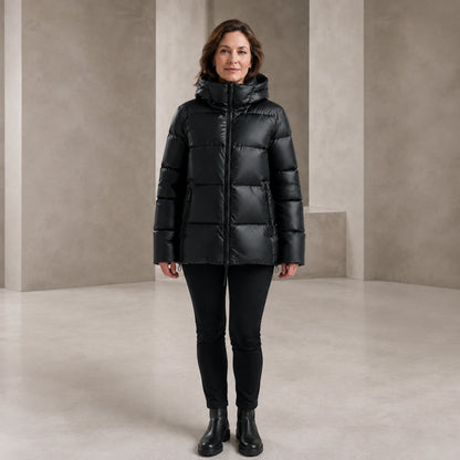 parka coat — Woman wearing glossy black hooded puffer coat, complete front view